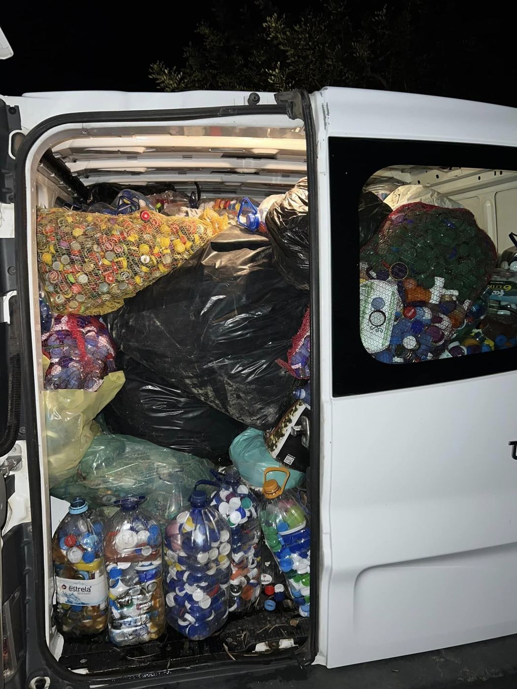 Uma carrinha branca cheia de sacos de tampas
