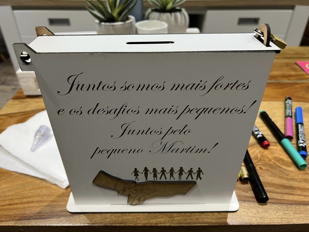 Uma caixa de donativos com a frase Juntos somos mais fortes e os desafios mais pequenos! Juntos pelo pequeno Martim!