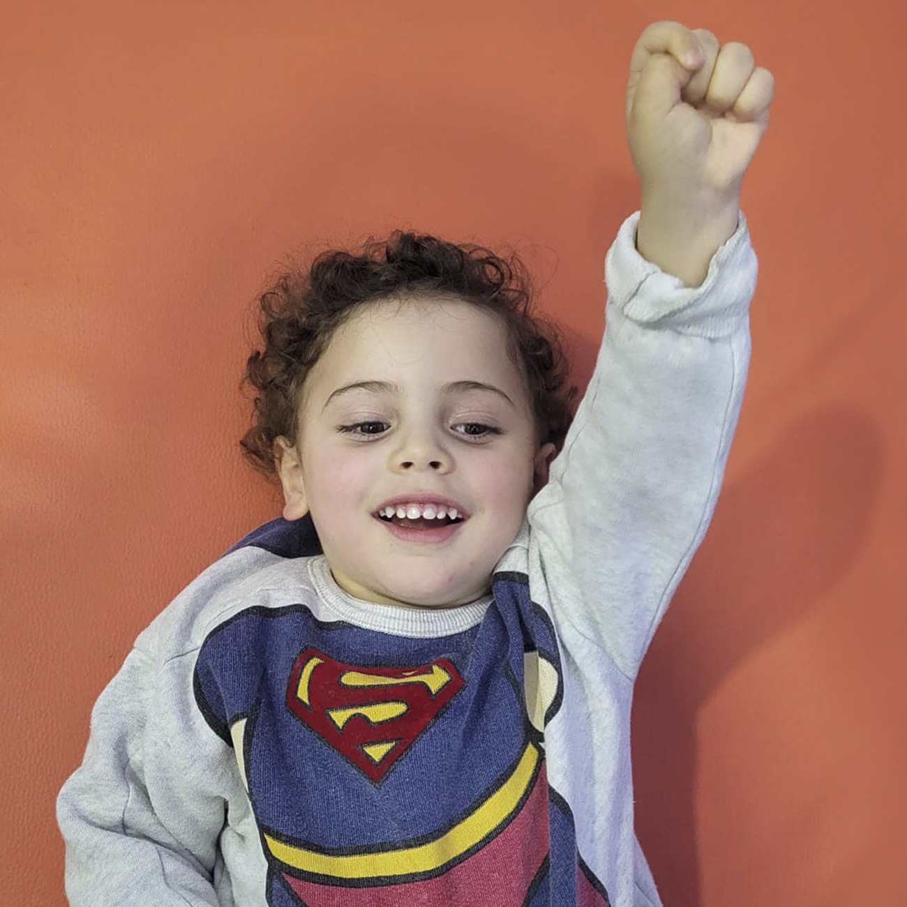 O Martim, sorridente, de braço no ar e punho fechado, com uma camisola do Super-Homem