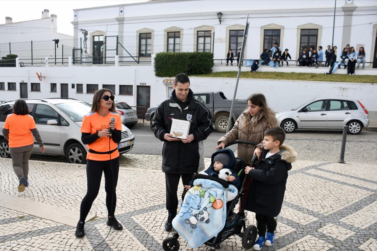 Pessoas a caminhar numa rua com um carrinho de bebé